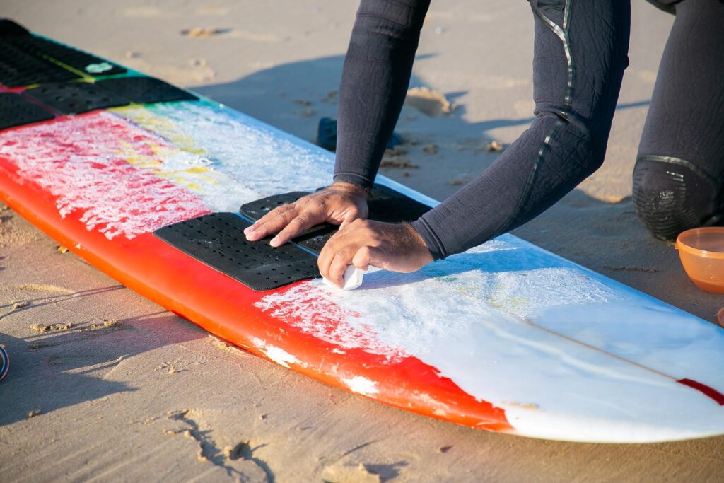 why wax a surfboard a guy showing how to do it and why to do it