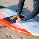 why wax a surfboard a guy showing how to do it and why to do it