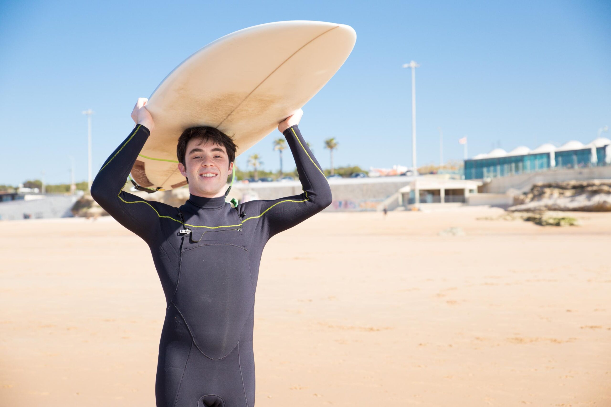 a guy with a surf board wearing a perfectly fitting wetsuit