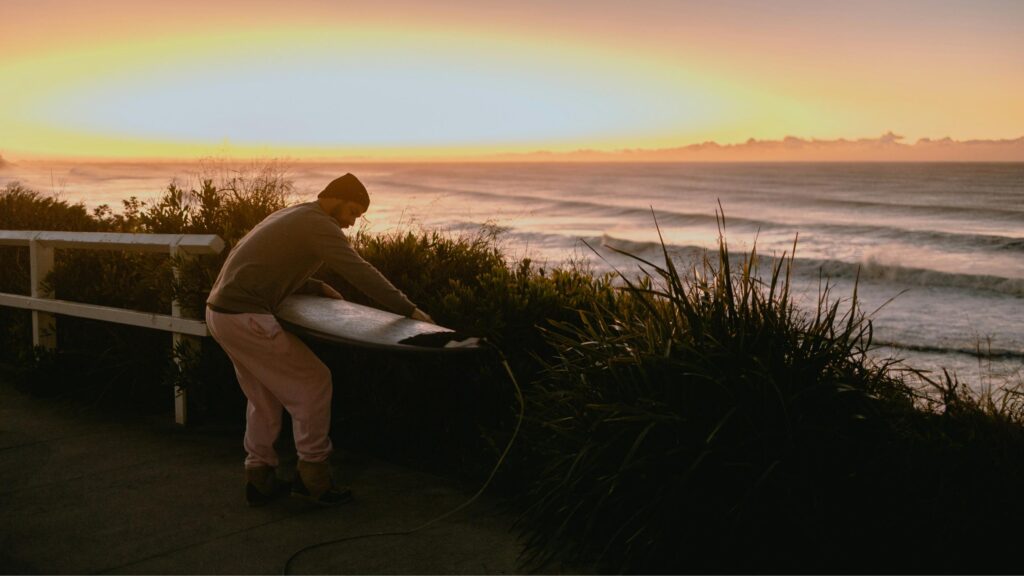 a surfer maintaining his surfboard