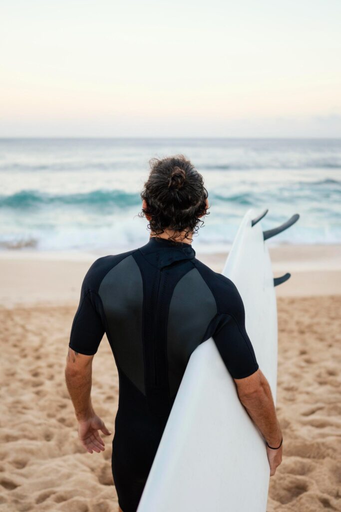 what to wear when surfing a westuite with a surfboard