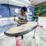 a person repairing a surfboard