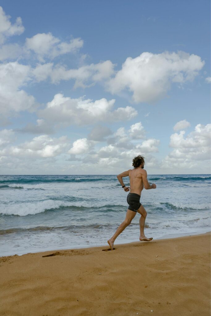 a guy runing on the beach