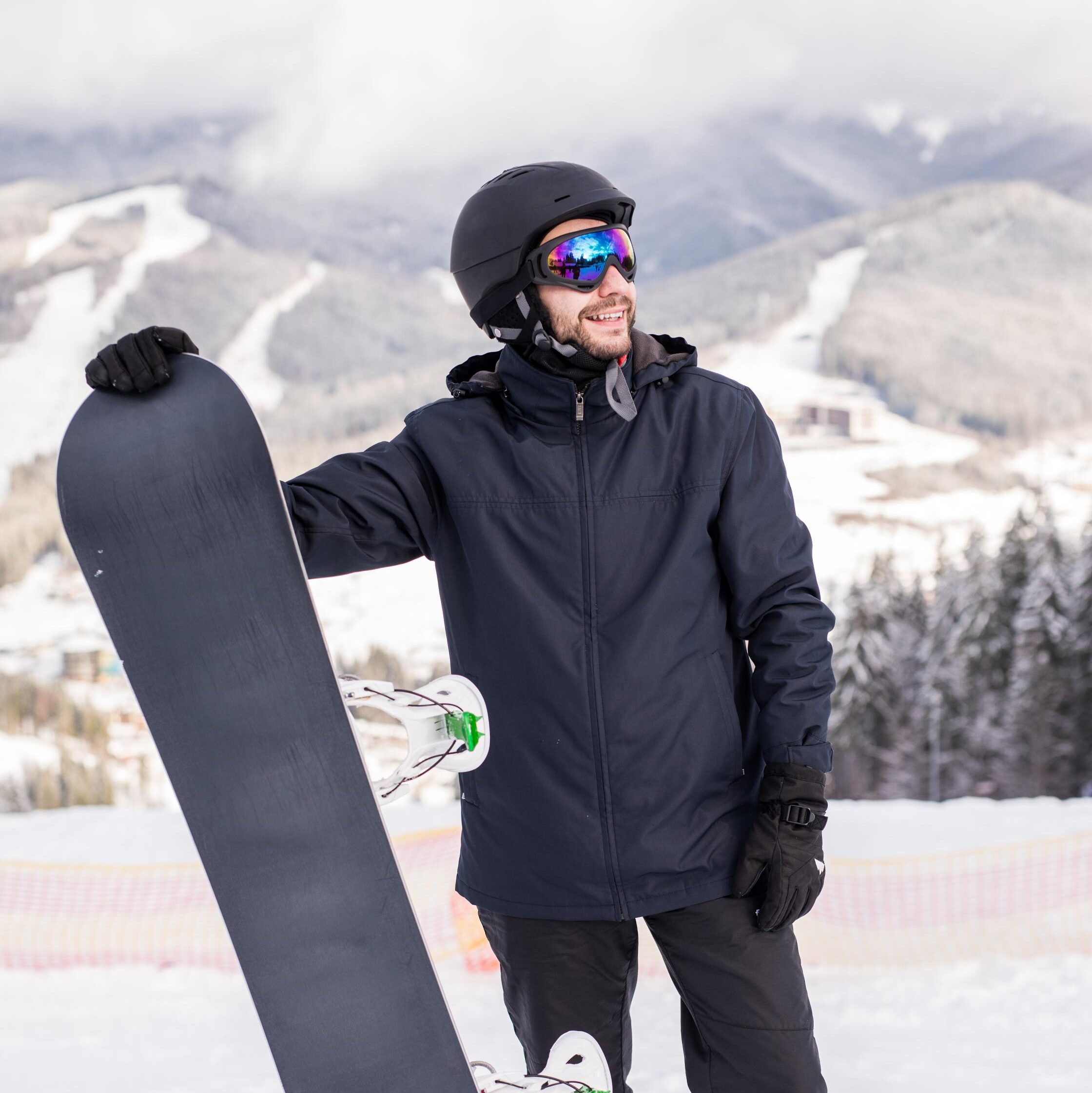 a guy holding a snowboard in the mountain