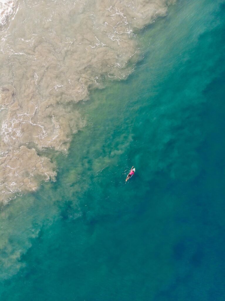 a sky view of a surfer in water