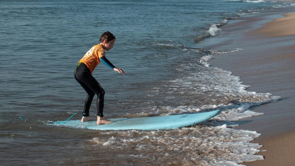 a kid learning his first steps in surfing