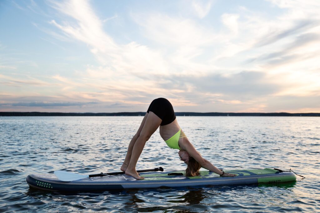 a girl on a surfboard doing stretches